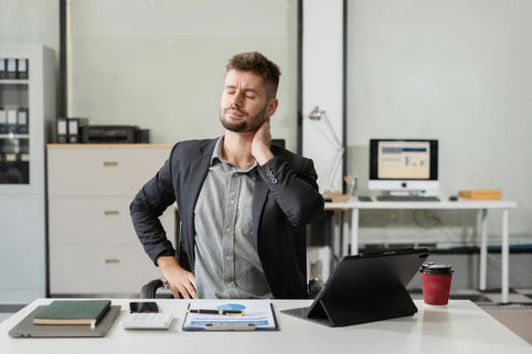 Male businessman is doing a stretchy posture due to sitting in the office for too long.